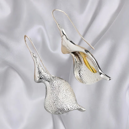 Silver and gold calla lily earrings on a satin background